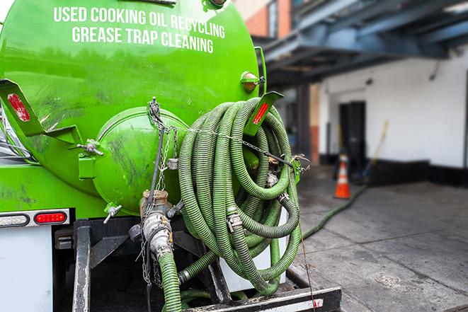 a technician pumping a grease trap in a commercial building in Huntley IL